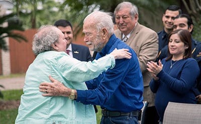 Bob Hensley hugs Becky Mingie, ADT Dispatcher