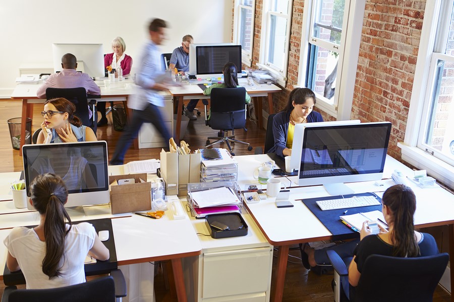 Wide Angle View Of Busy Design Office With Workers At Desks