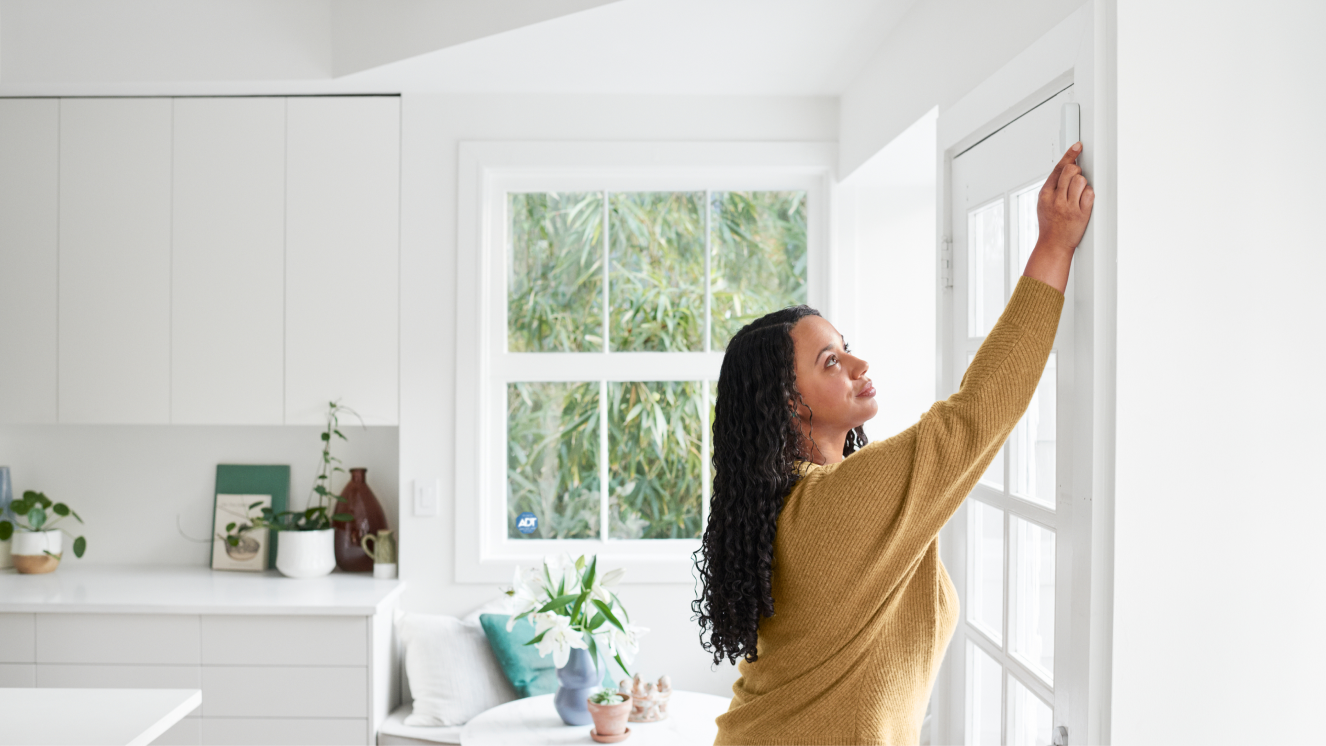 Woman self installing a window sensor in her home