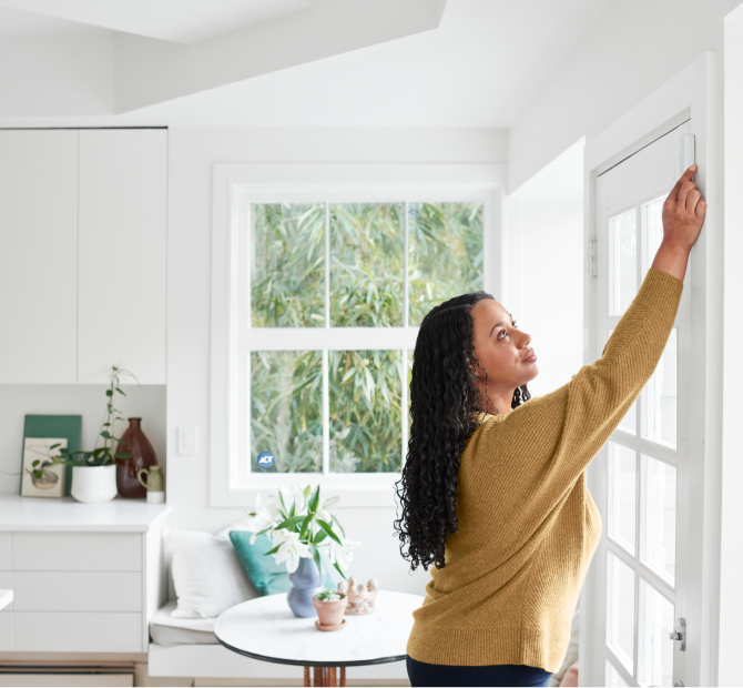 Woman self installing a window sensor in her home